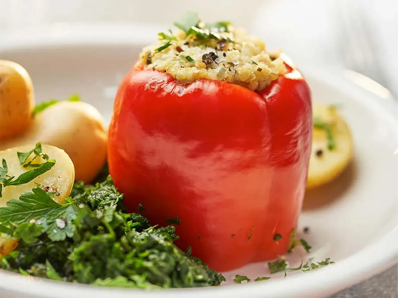A vegetarian Cookit recipe: red bell peppers stuffed with bulgur wheat. Served with spinach, parsley and potatoes. 