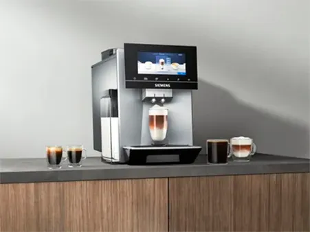 A Siemens coffee machine on a countertop, showcasing various coffee drinks in glasses beside it.