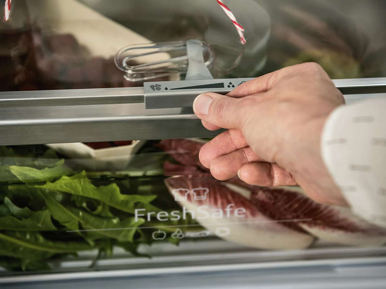Eine Hand stellt das Eco Air Flow-System über einer Fresh Safe-Schublade in einem Kühlschrank ein.