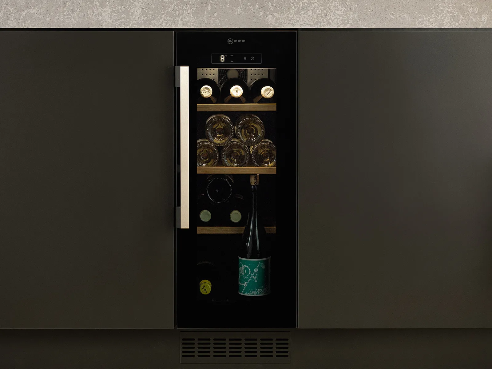 A narrow wine cooler half the width of a kitchen cupboard, integrated underneath a kitchen island.