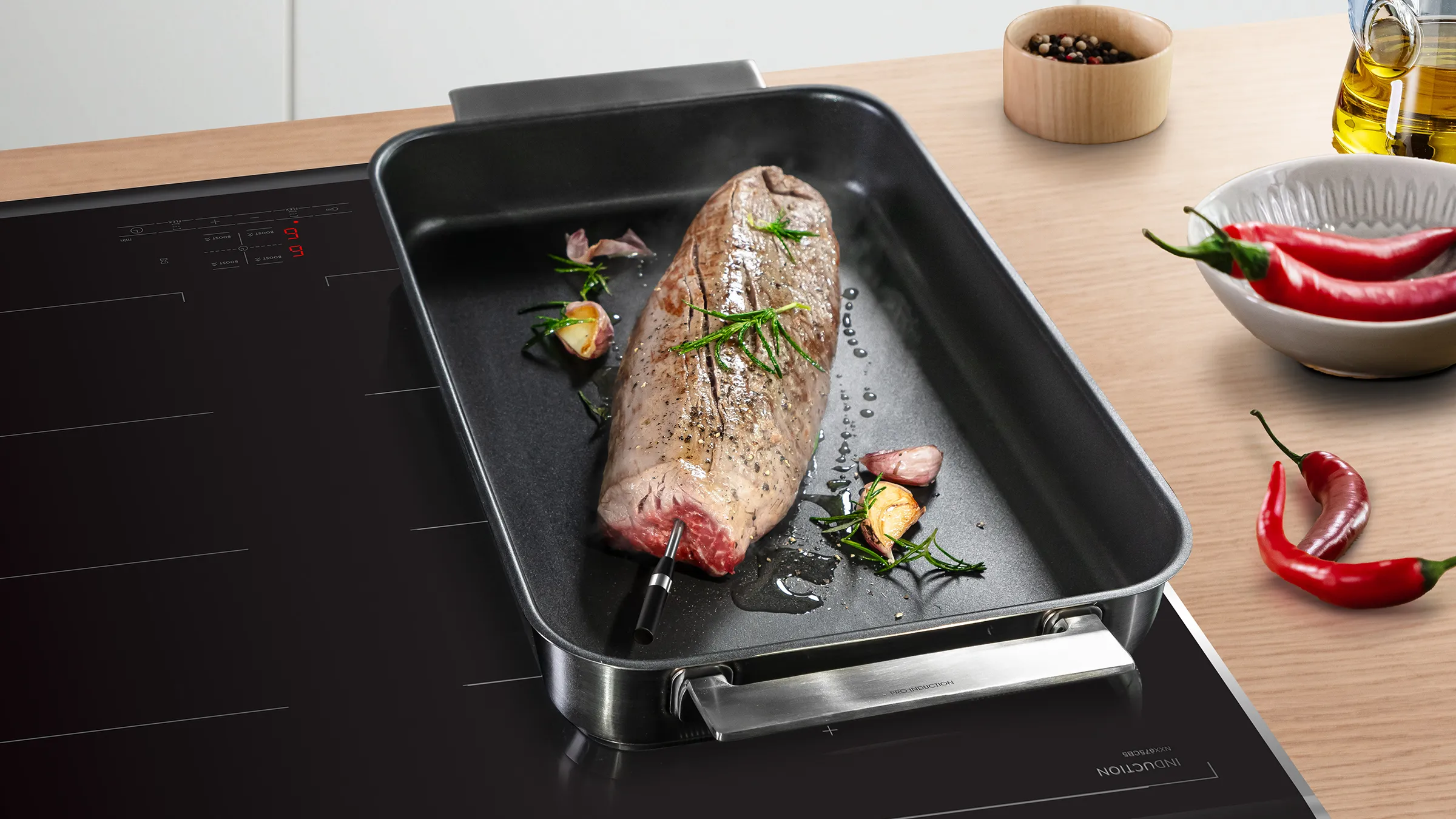 Fleischbraten mit integriertem Bosch PerfectRoast Fleischthermometer in einem Bräter auf einem Induktionskochfeld.