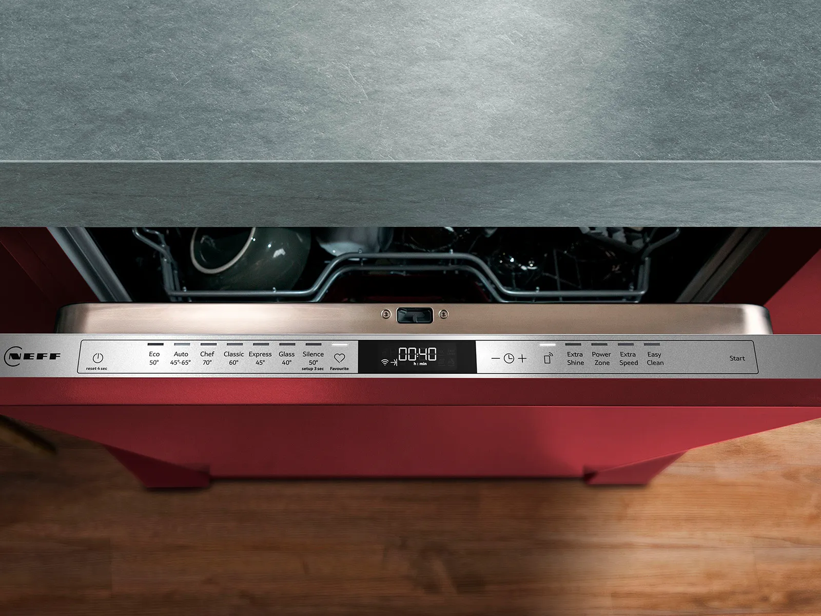 Close-up of a NEFF dishwasher control panel displaying settings and a countdown timer, with dishes visible inside.