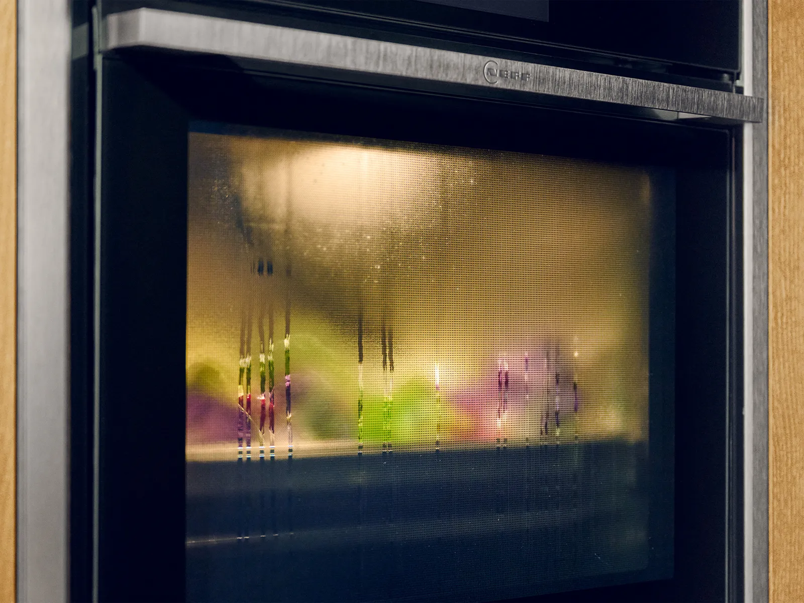 Close-up of N90 Metallic Silver oven showing Intensive Steam behind the steamed up oven door  