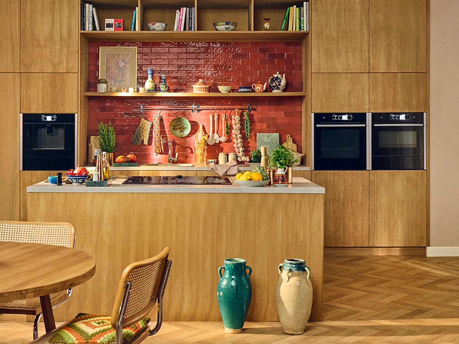 A wooden kitchen with red tiles, twin ovens and big island