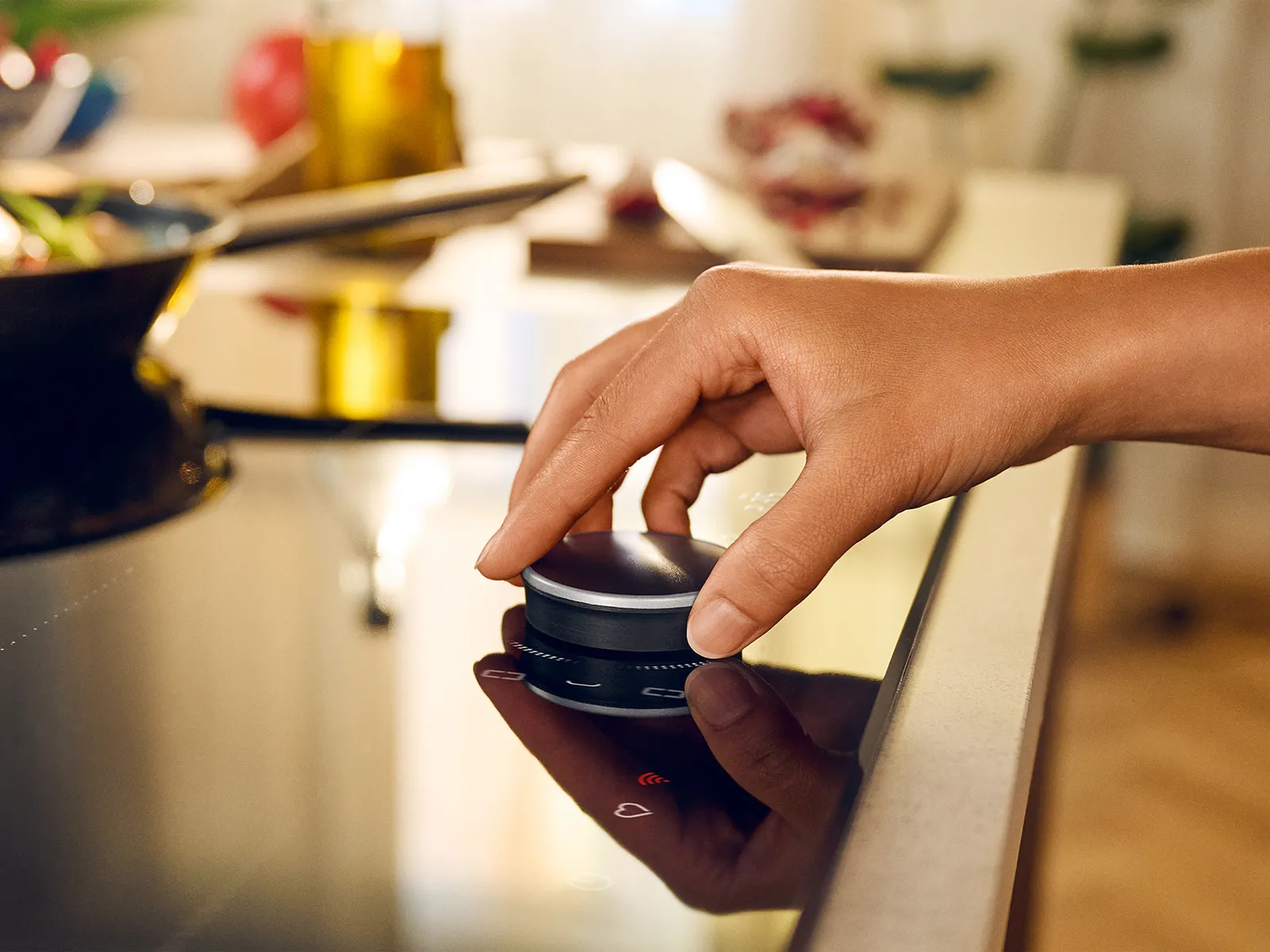 Female hand placing Twist Pad Flex on cooktop, shot from the side