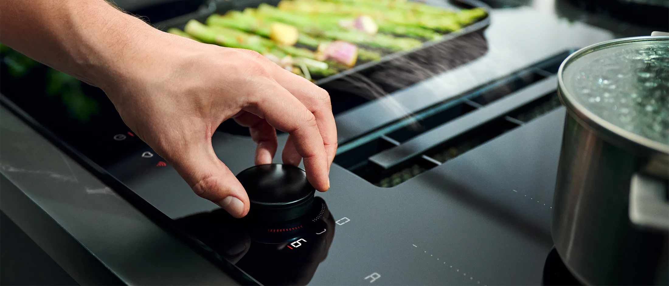 Hand twsiting Twist Pad Flex on vented cooktop