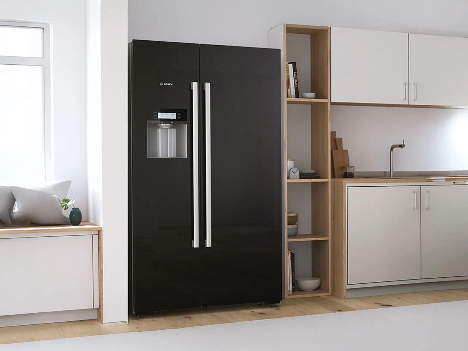 Modern black Bosch refrigerator with double doors, next to a light wood kitchen cabinet.