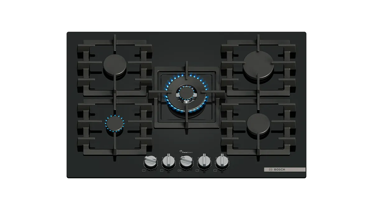 A sleek black gas cooktop with five burners, featuring a central illuminated burner and metallic knobs.