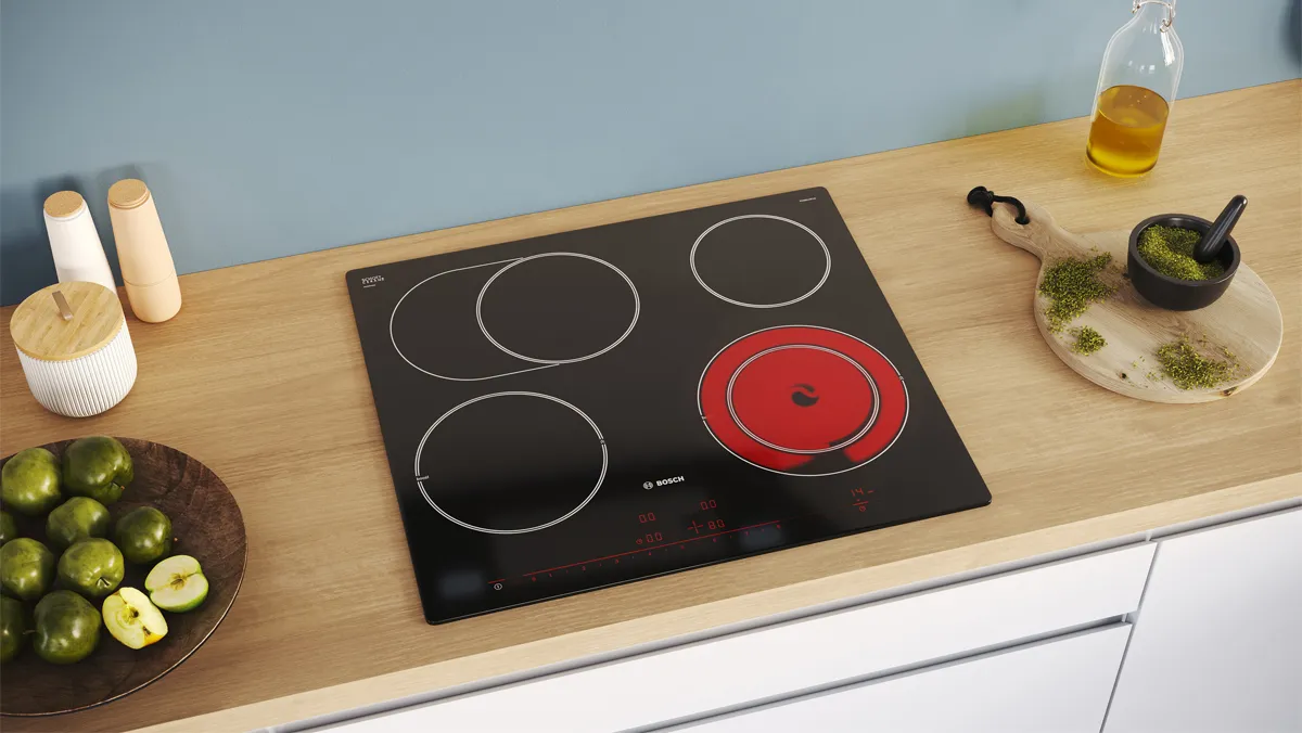 A black Bosch ceramic hob with one burner turned on.