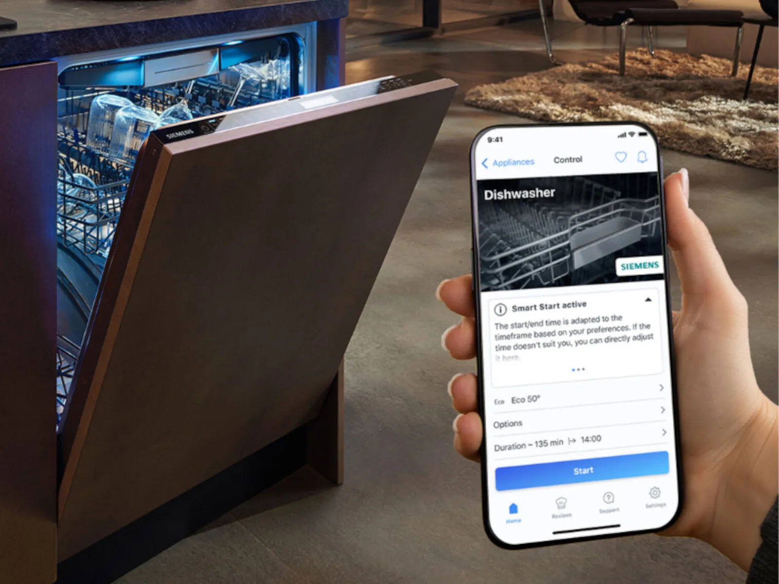 A modern dishwasher with an open door alongside a smartphone showing the appliance control app.