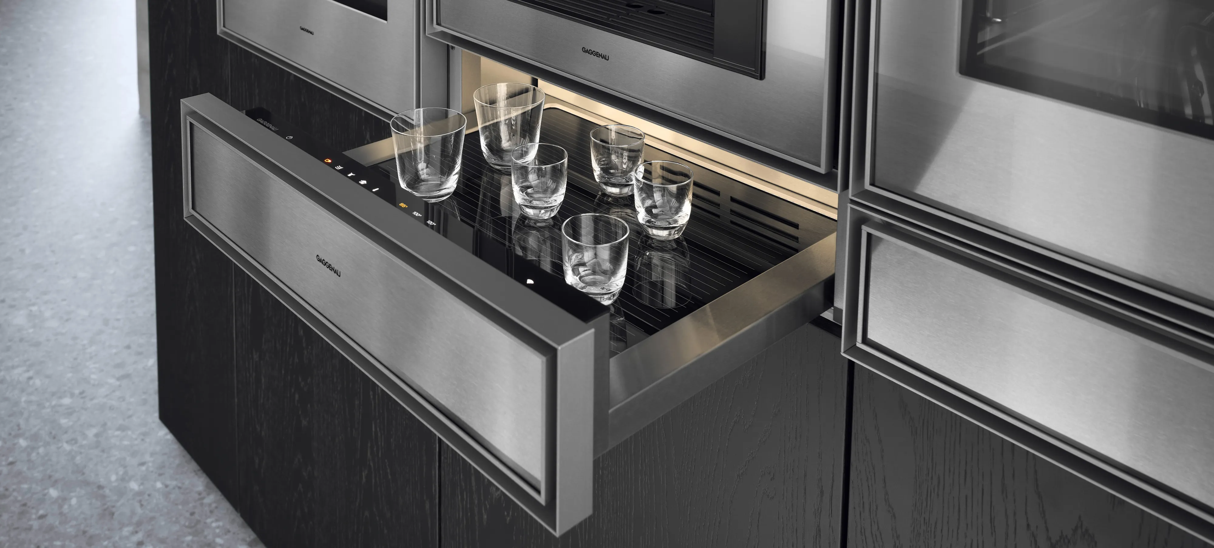 Close-up of an open Gaggenau Expressive culinary warming drawer warming coffee cups