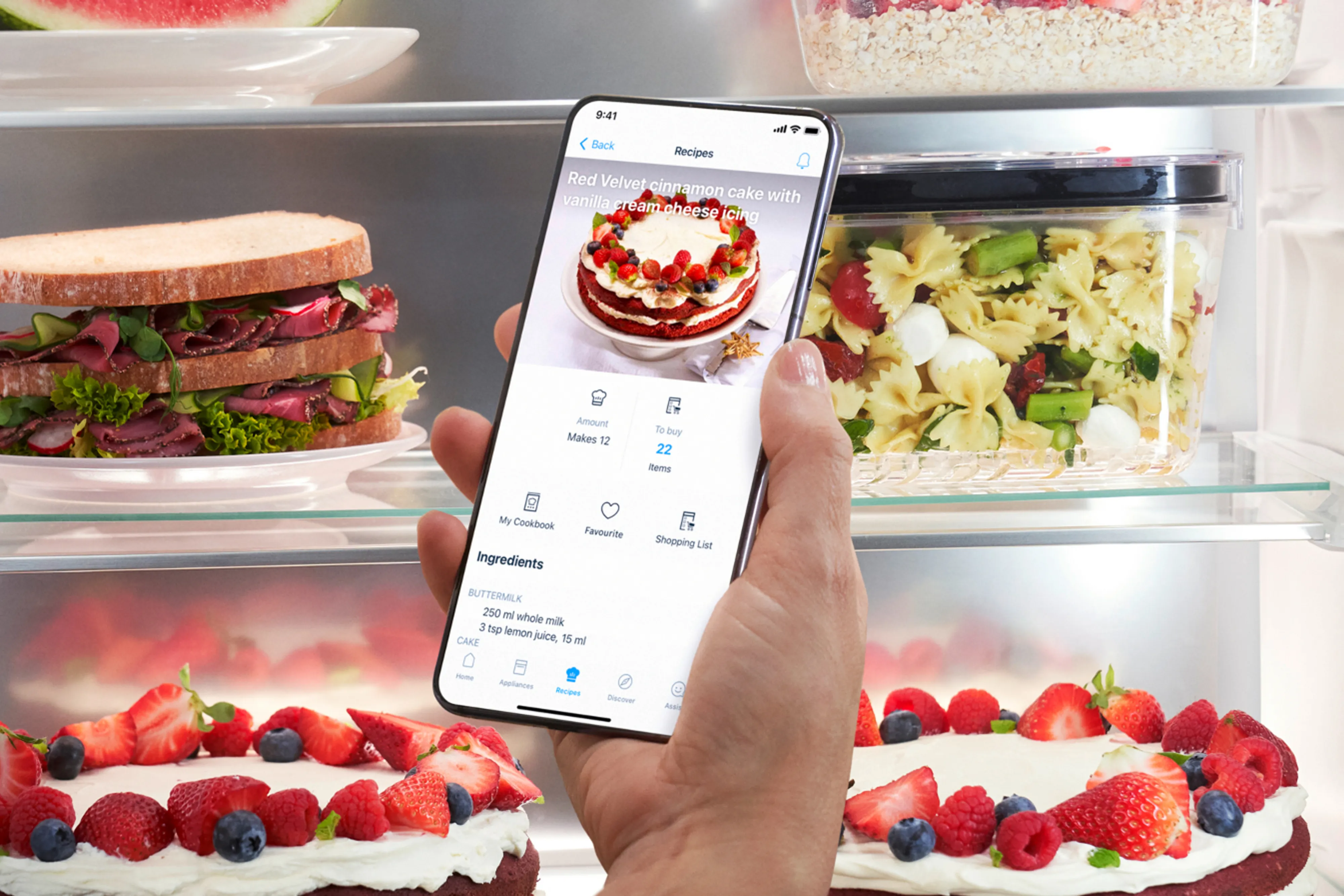 A person holds a smartphone displaying a photo of food items inside a refrigerator. 