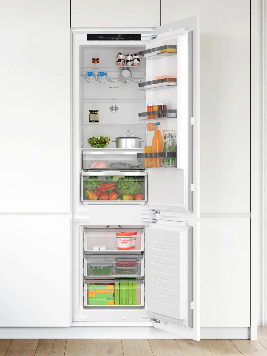 Refrigerator with open doors, displaying various food items and shelves.
