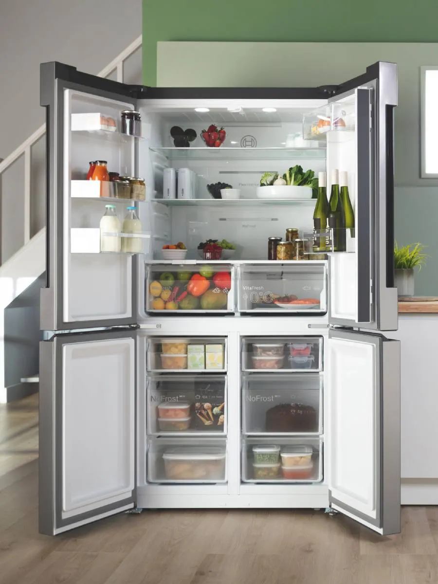 Stainless steel four-door refrigerator with sleek, modern design and digital controls.