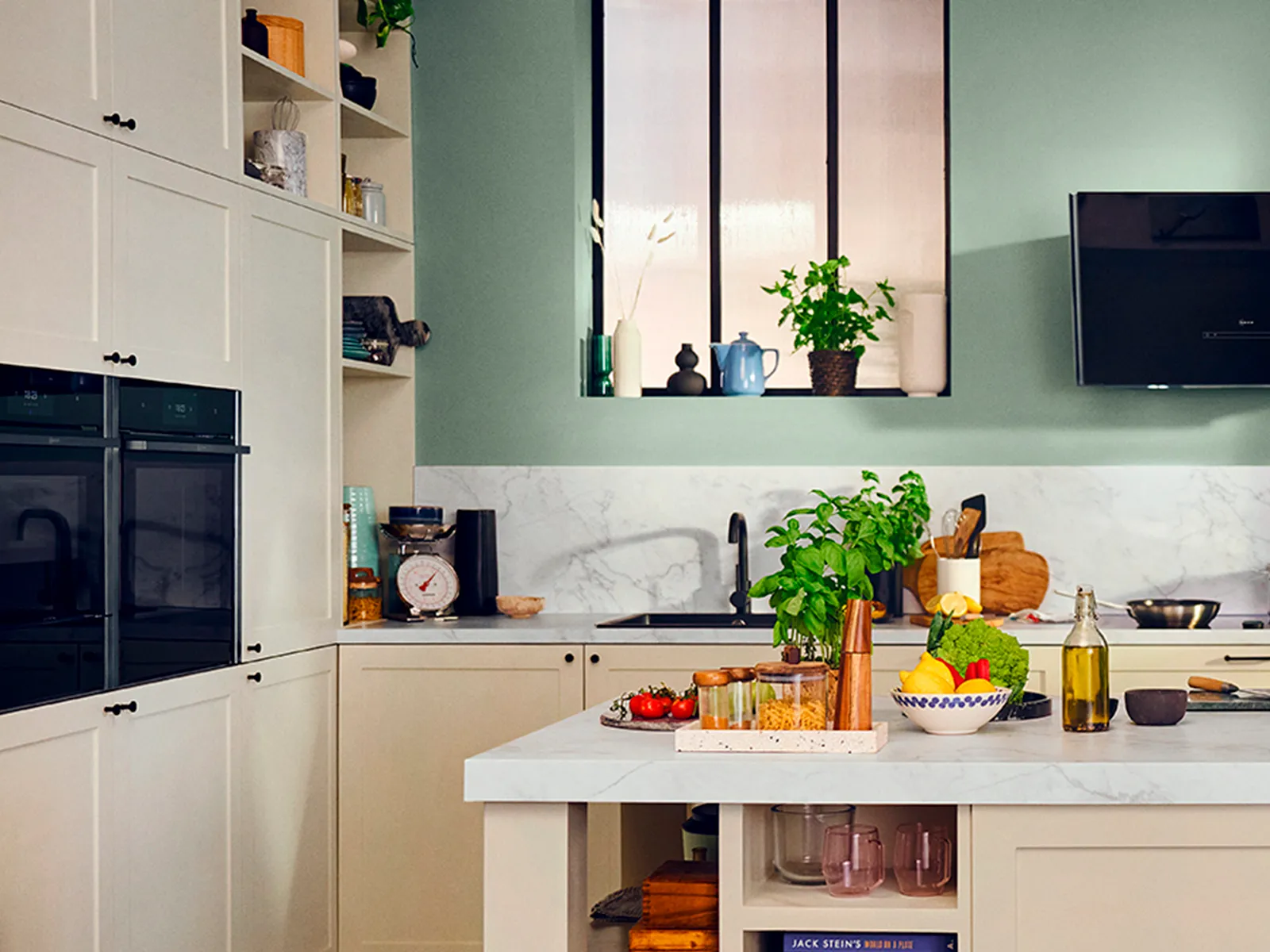 Modern kitchen with black cabinetry, built-in NEFF appliances, a stylish island, and large industrial-style windows.