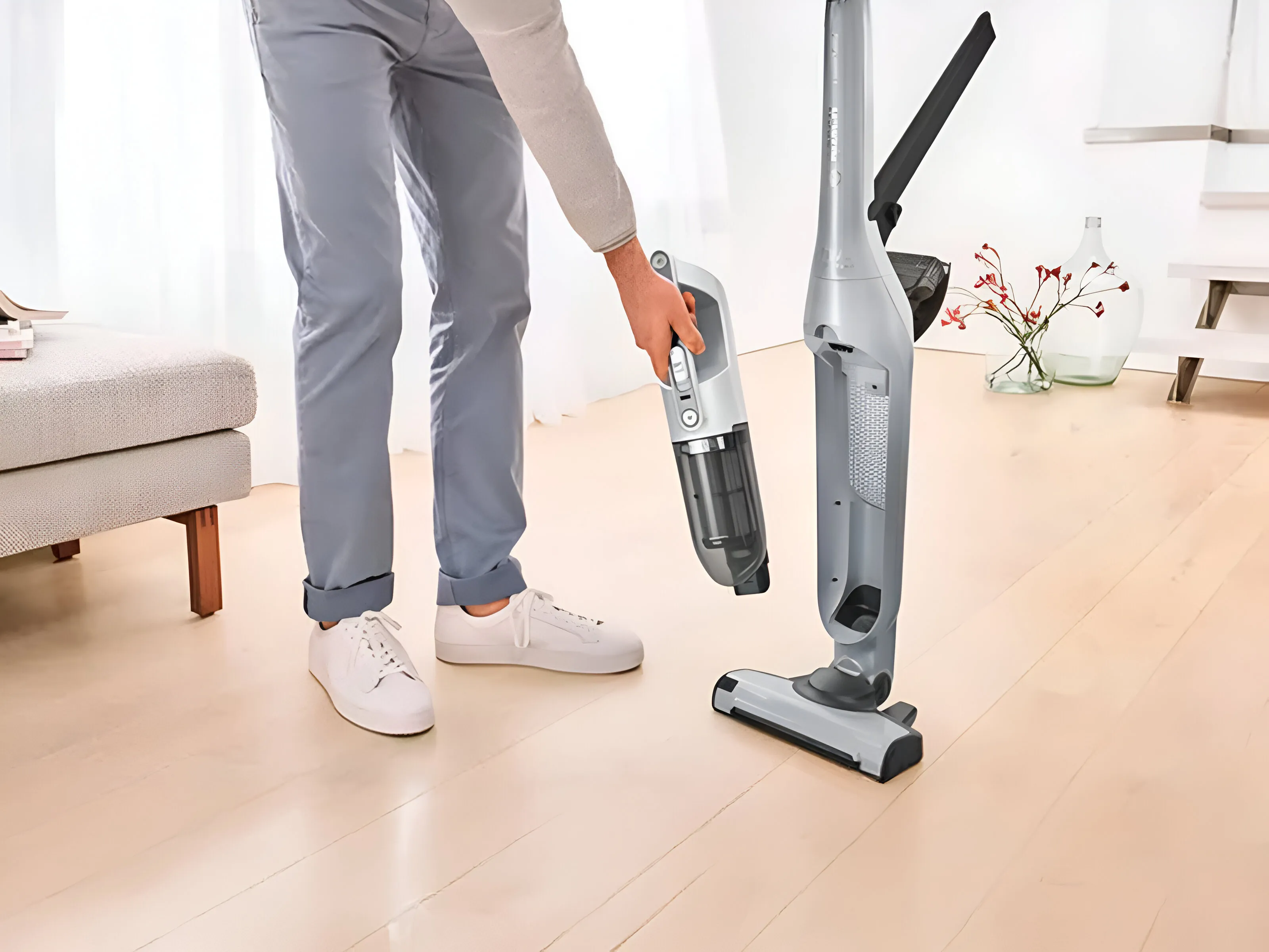 Der kabellose Staubsauger Flexxo steht in der Mitte eines Raumes, die integrierten Zubehörteile sind sichtbar.