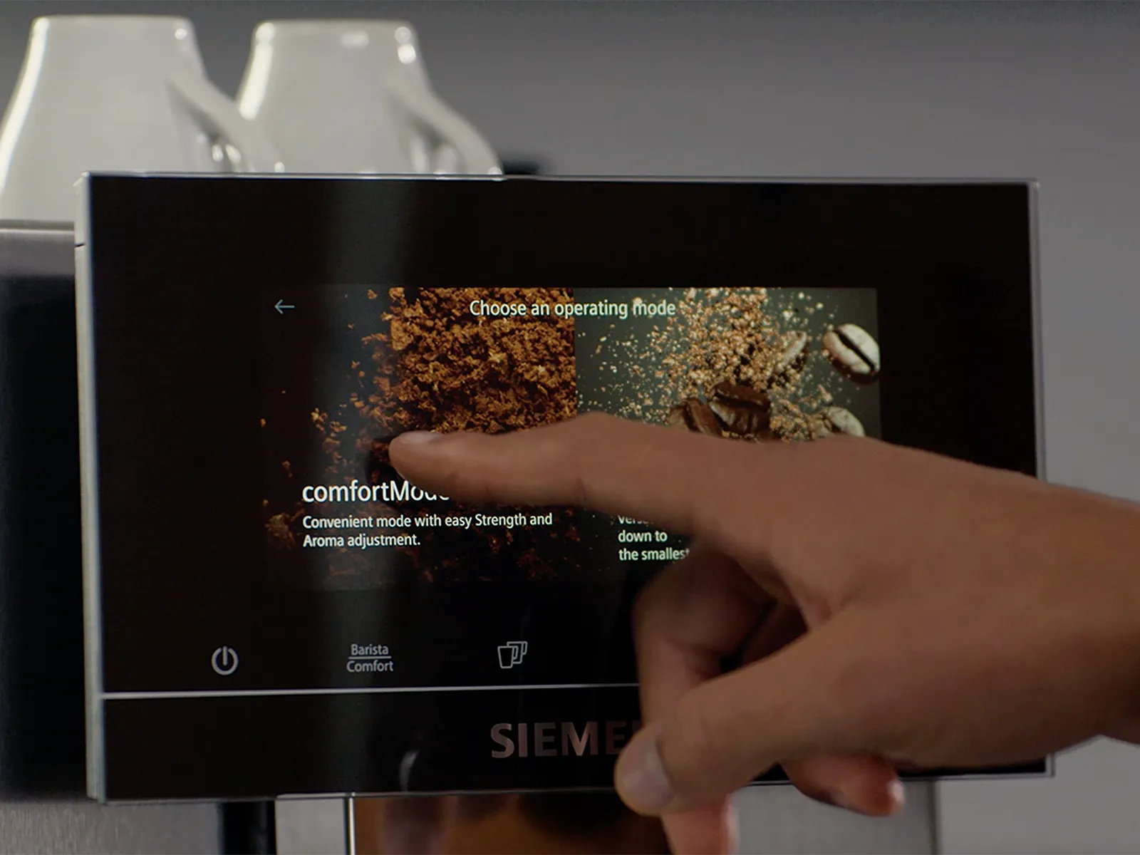 Deget care selectează ‘comfortMode’ pe ecranul tactil al espressorului Siemens.