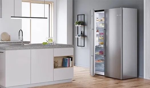 Moderne Küche mit einem geöffneten Kühlschrank aus Edelstahl, dessen Regale mit Lebensmitteln gefüllt sind, neben einer eleganten Kücheninsel.