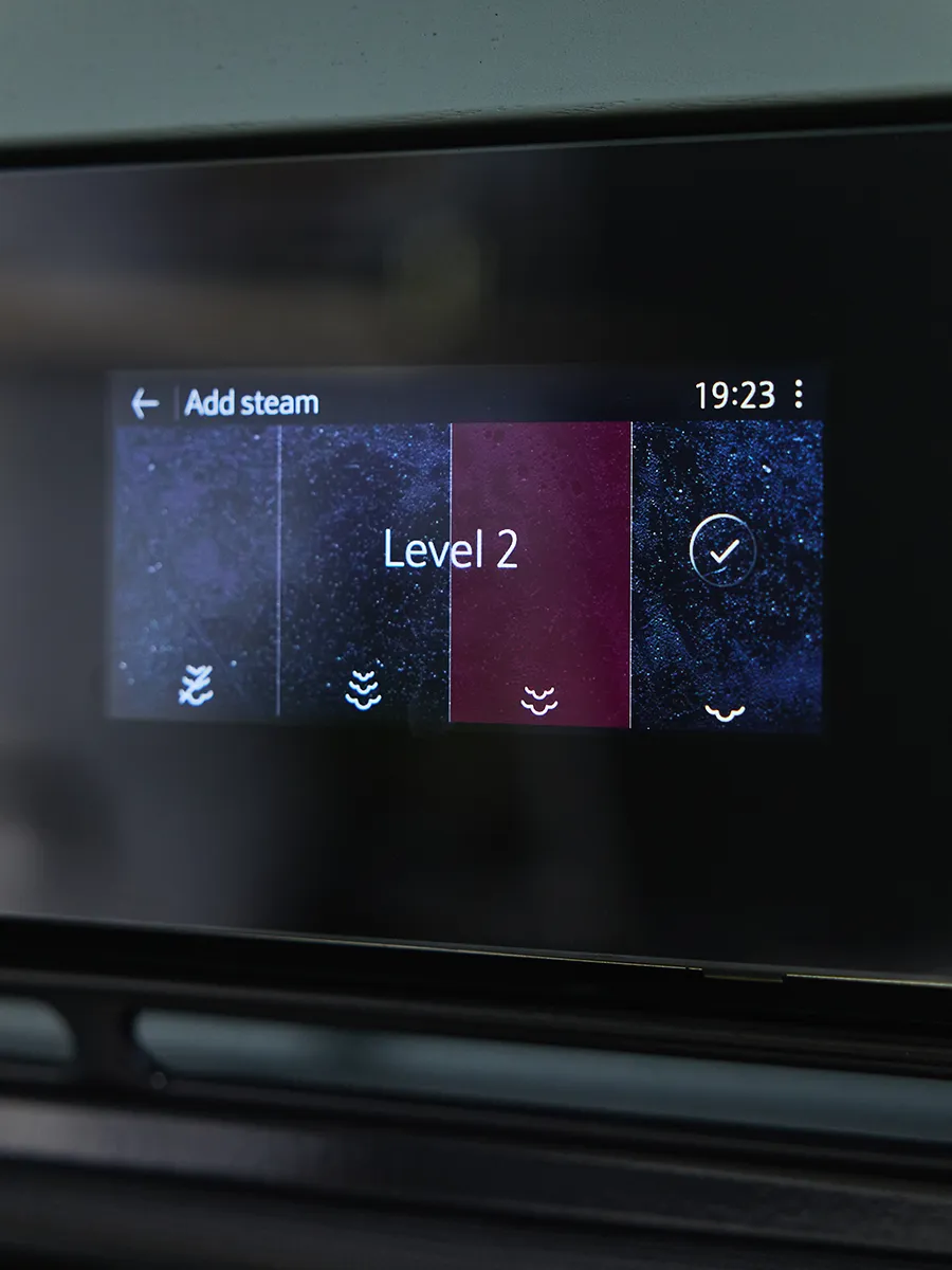 A close-up of the digital touchscreen display of a NEFF oven. The menu shows the "Add steam" function, with "Level 2" highlighted in red as the selected steam intensity.