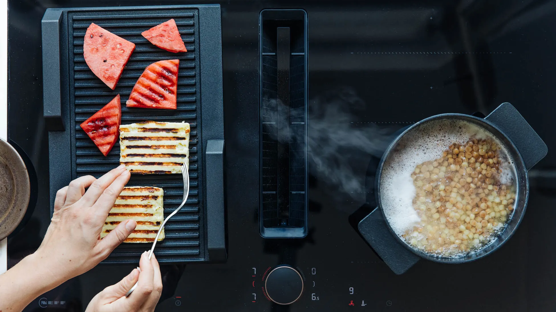 A person skillfully cooks food on a grill, utilizing a frying sensor for optimal temperature control.