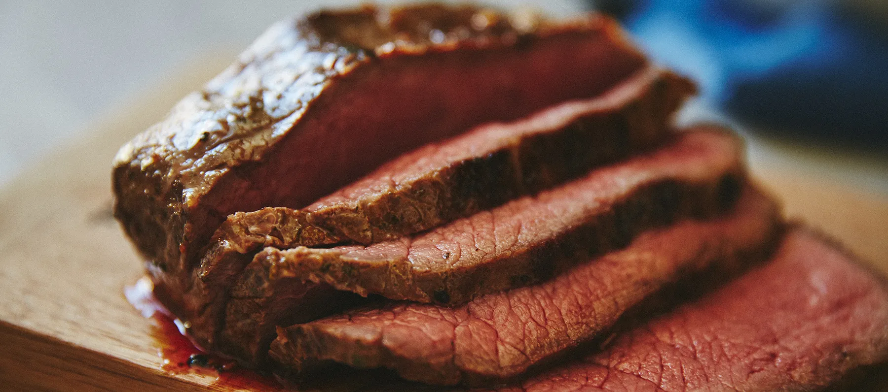 Sliced roast beef on wooden board