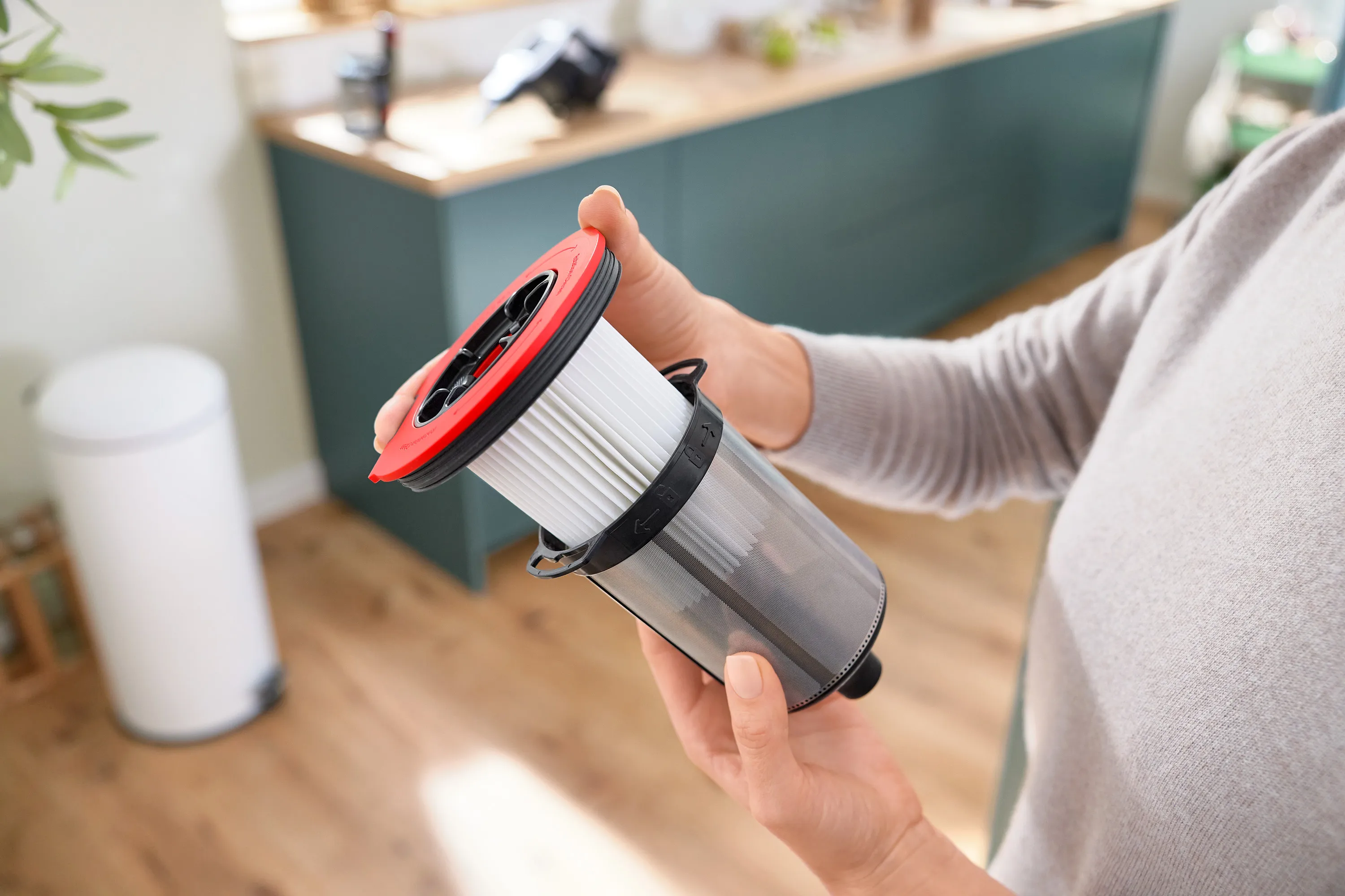 O persoană ține în mână un filtru de aspirator