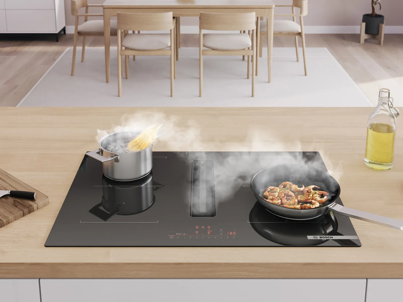 Modern induction cooktop with integrated vent, pot of pasta and pan with food on the stove.