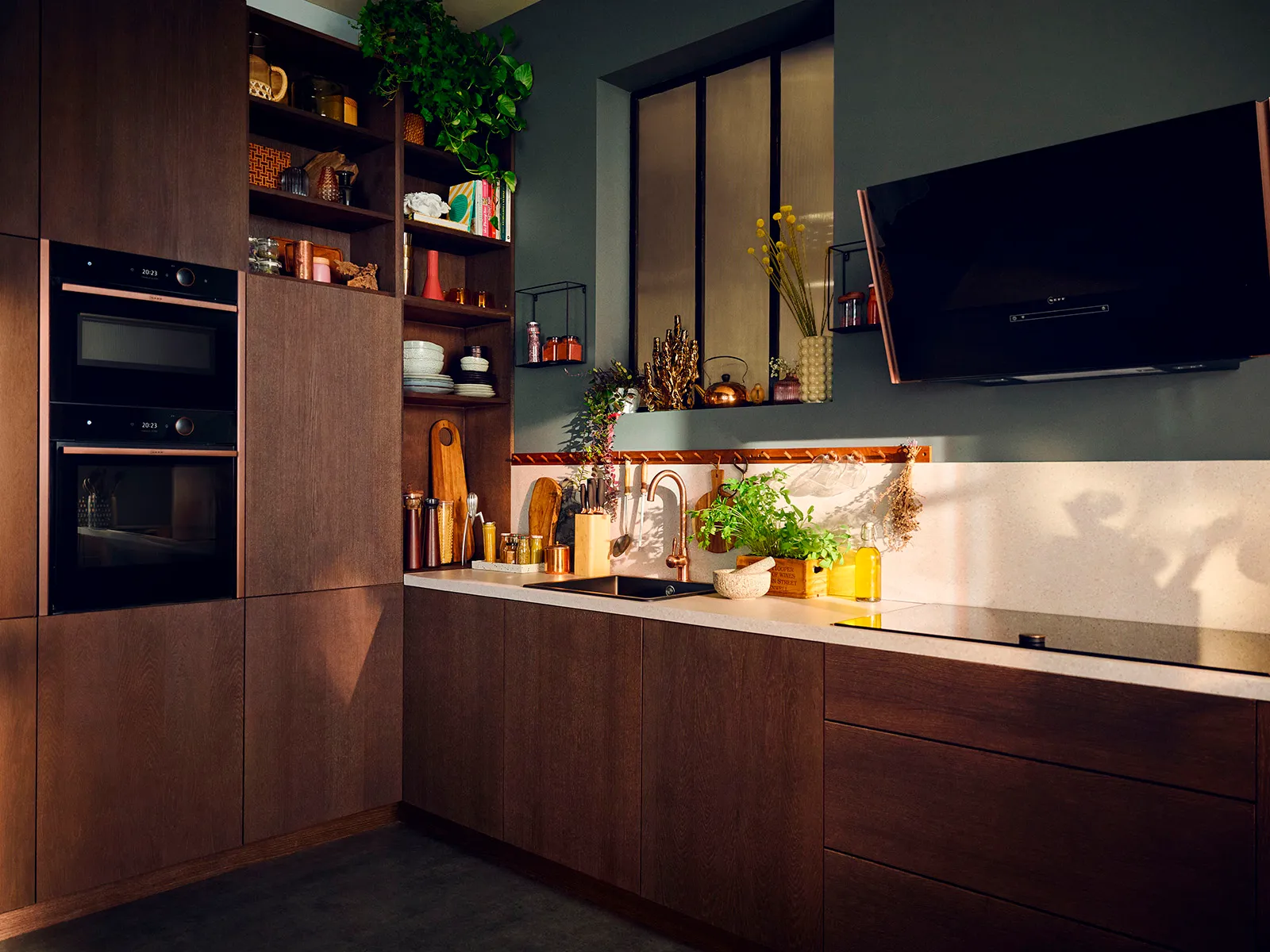 Modern kitchen with dark wooden cabinets, polished countertop, and a mix of plants and utensils.