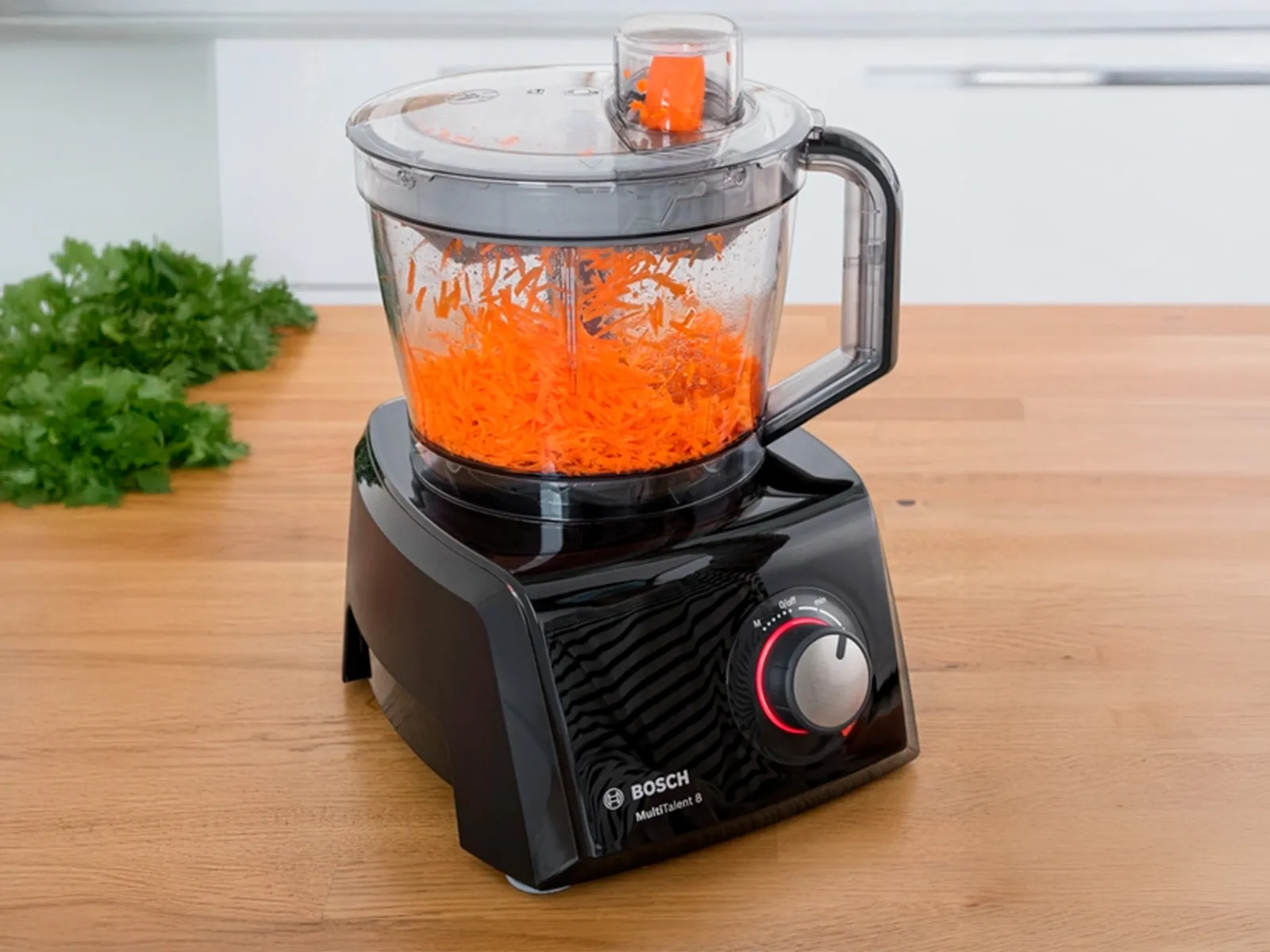 Un robot de cuisine Bosch MultiTalent 8 avec des carottes râpées à l’intérieur.