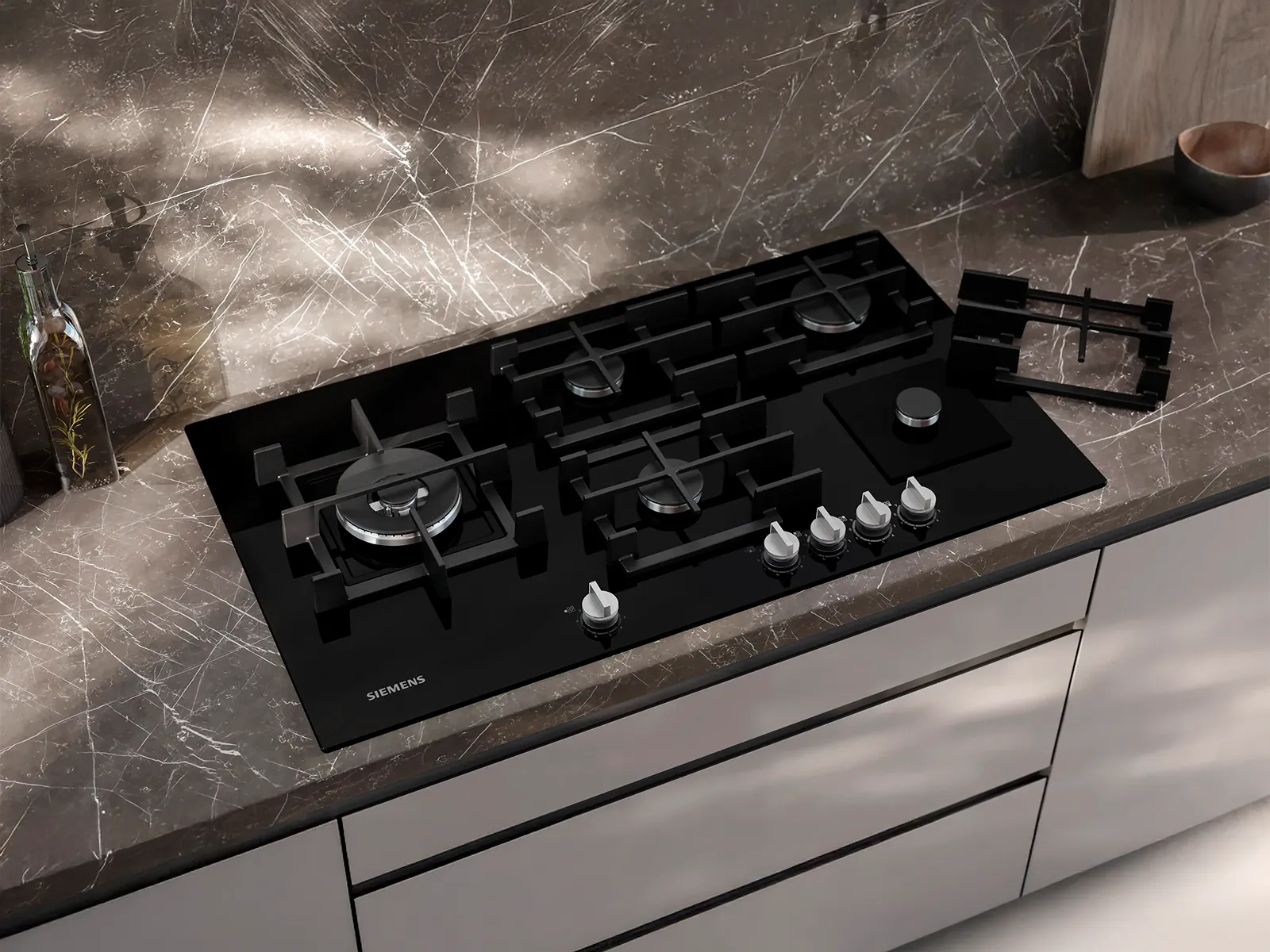 A top-down view of a Siemens gas hob in a grey marble countertop.