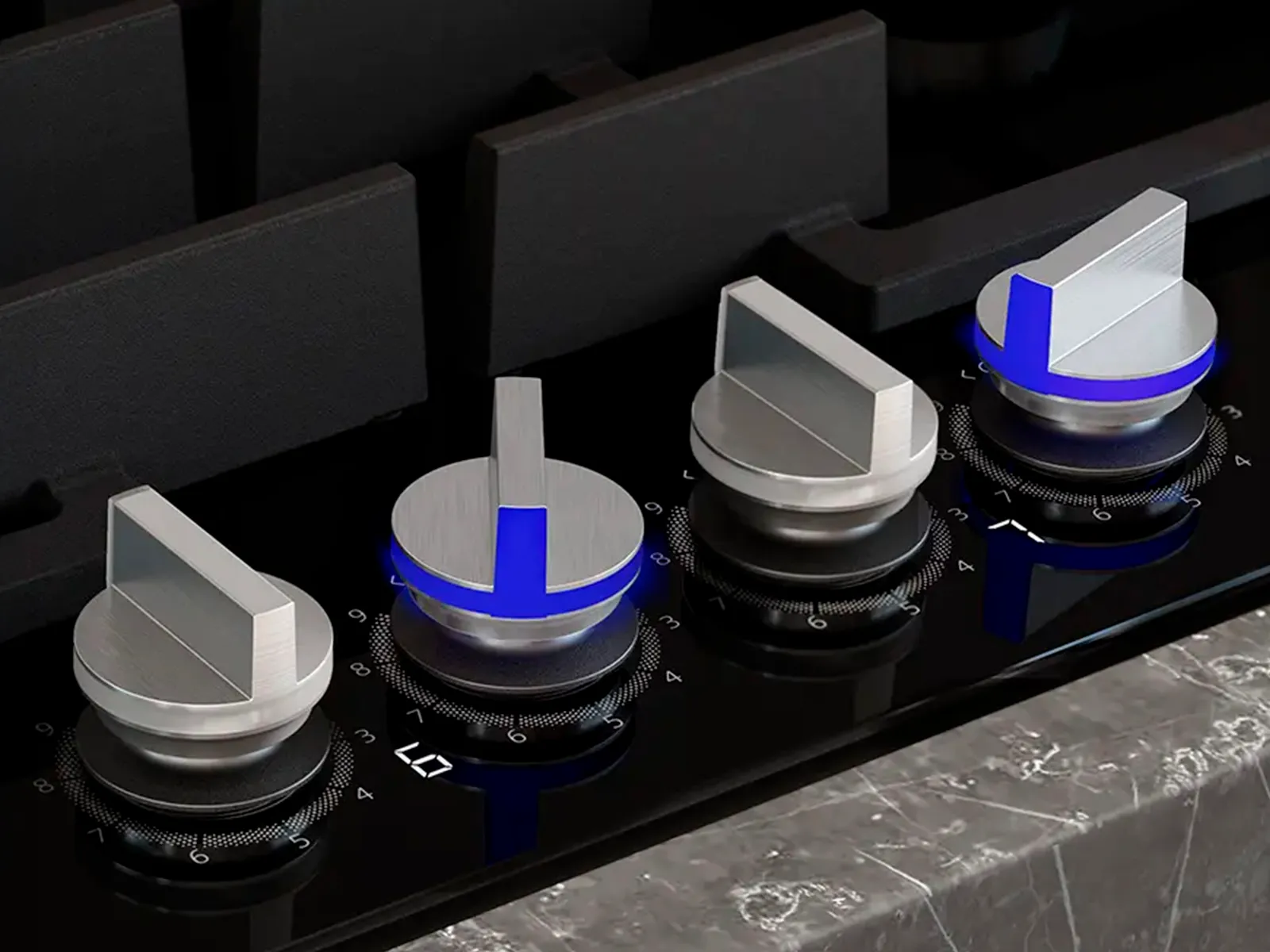 Four detachable knobs on a Siemens gas hob with tow knobs illuminated with blue LED lighting.