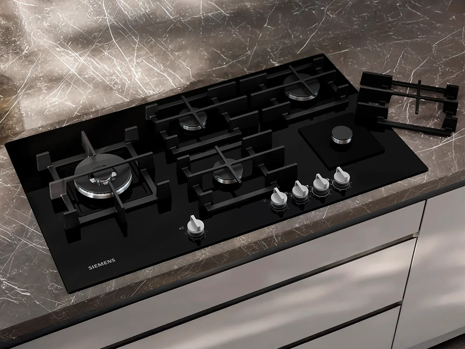 Top-down view of a Siemens gas hob in a grey marble kitchen countertop.