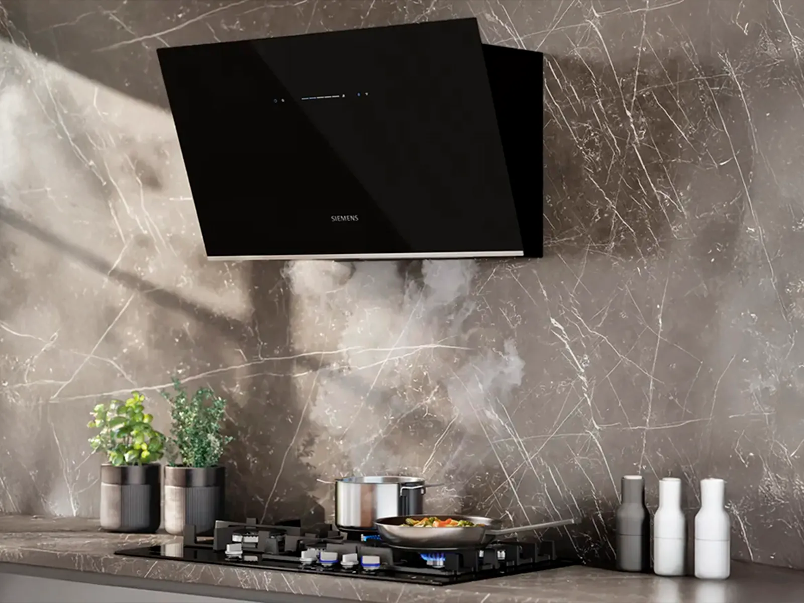 A Siemens gas hob in a grey marble kitchen with steam going into a Siemens extractor hood above.