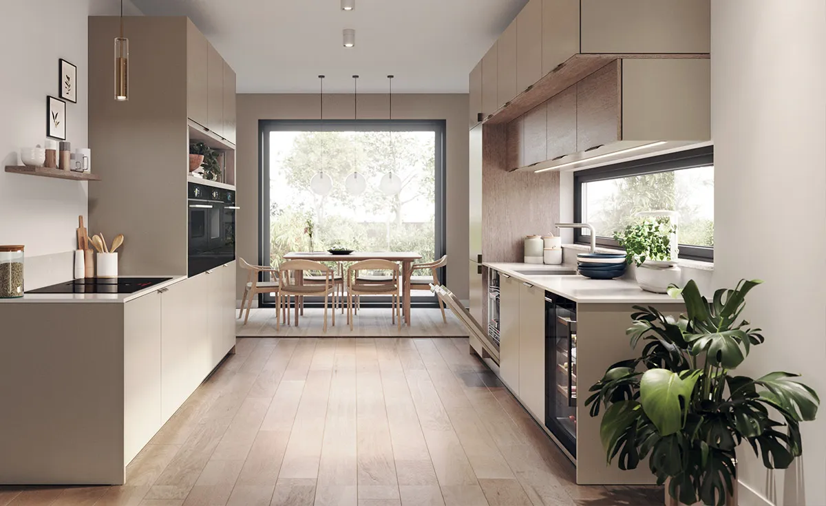 Cucina moderna con mobili beige, isola centrale, tavolo da pranzo vicino a finestra ampia e pianta verde in primo piano