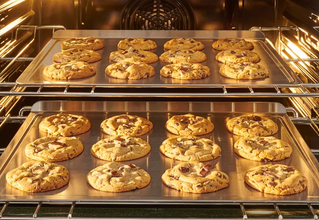 two trays of chocolate chip cookies being cooked in Bosch 100 series range oven