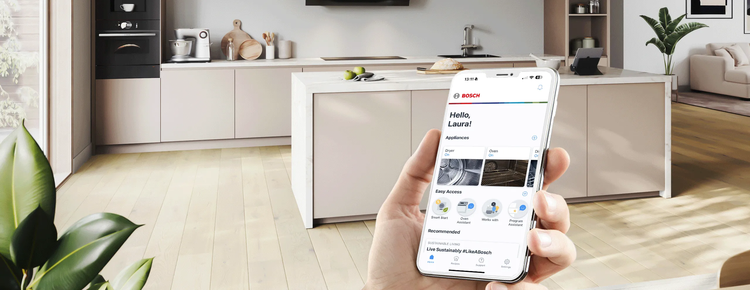 Eine Hand hält ein Smartphone mit der Bosch Home Connect App in einer modernen, hellen Küche.
