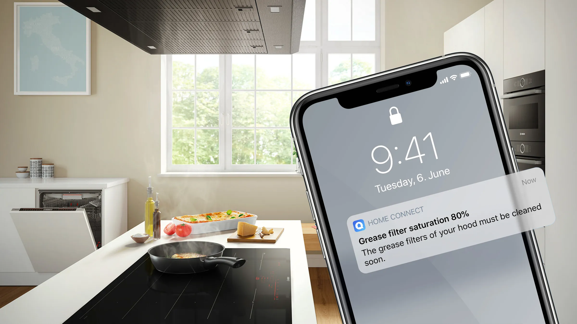 Ein Smartphone im Vordergrund zeigt eine Home Connect Push-Nachricht zur Fettfiltersättigung der Dunstabzugshaube in einer modernen Küche.