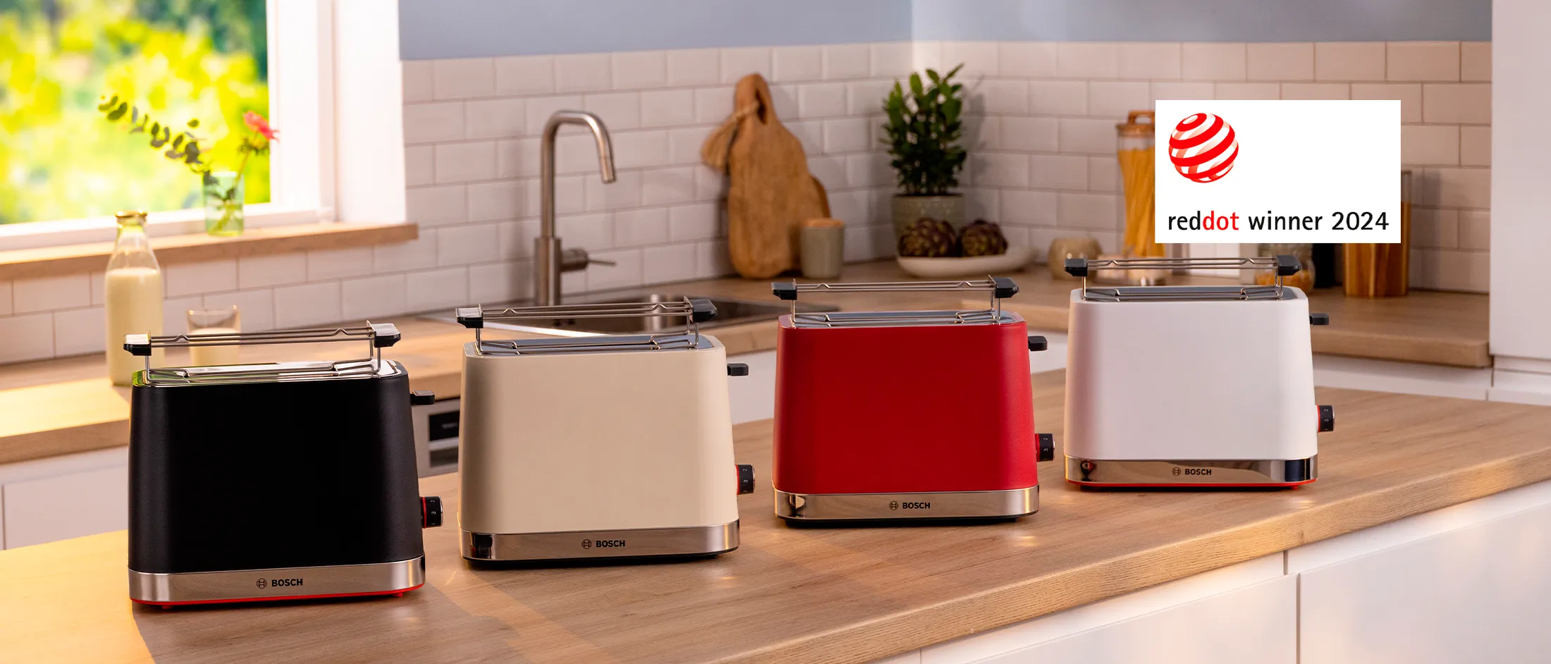 Uma linha de torradeiras Bosch em preto, creme, vermelho e branco sobre uma bancada de cozinha, exibindo seu Prêmio de Design Red Dot 2024.