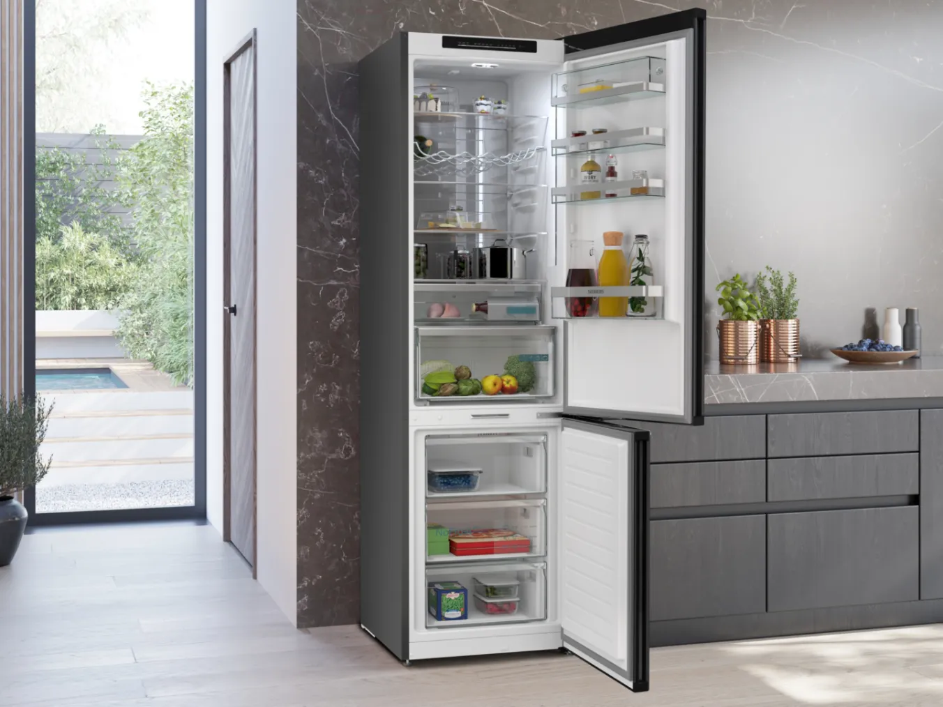 Vrijstaande koel-vriescombinatie van Siemens, openstaand zicht en gevuld met verse boodschappen.