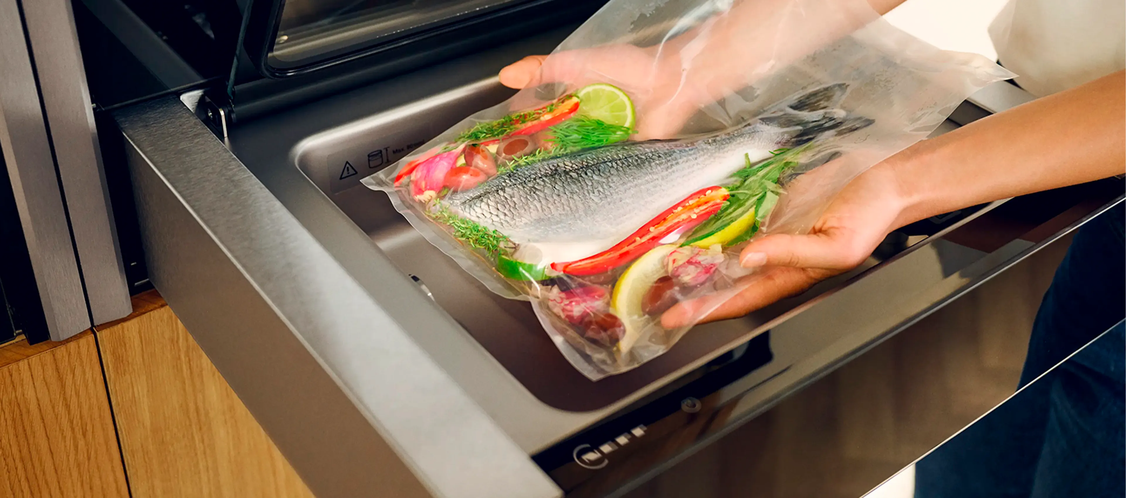 A person holds a clear bag containing a fish, showcasing the fish's vibrant colors and details. 