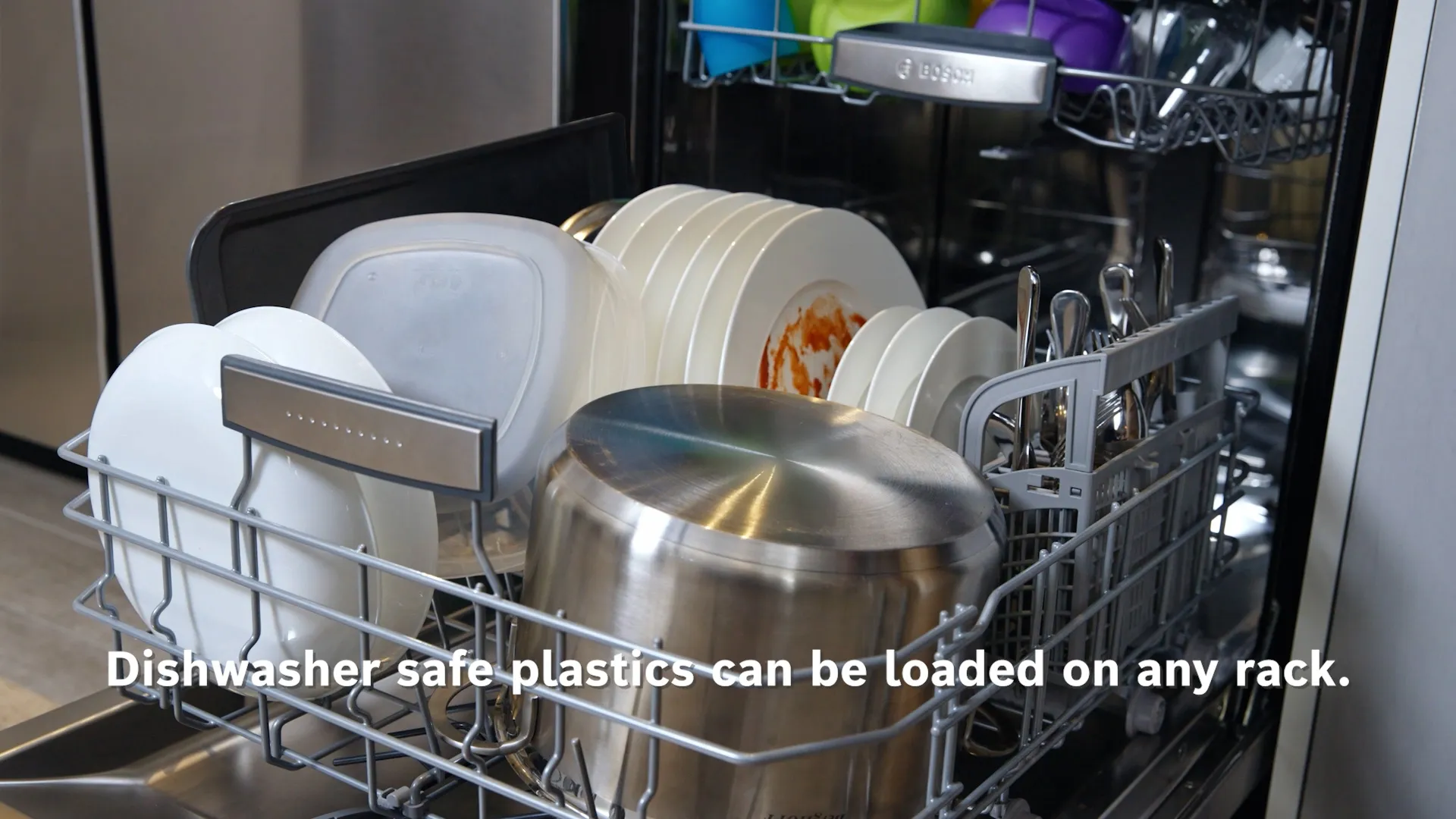 Open Bosch dishwasher loaded with various dishes and text about safe plastic loading.