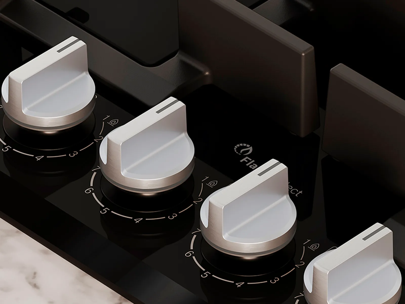 Close-up of a sleek black gas stove top featuring four silver knobs for burner control.