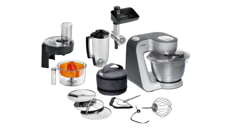 A Bosch kitchen machine with various attachments, including a blender, food processor, and whisks, arranged neatly on a white background.