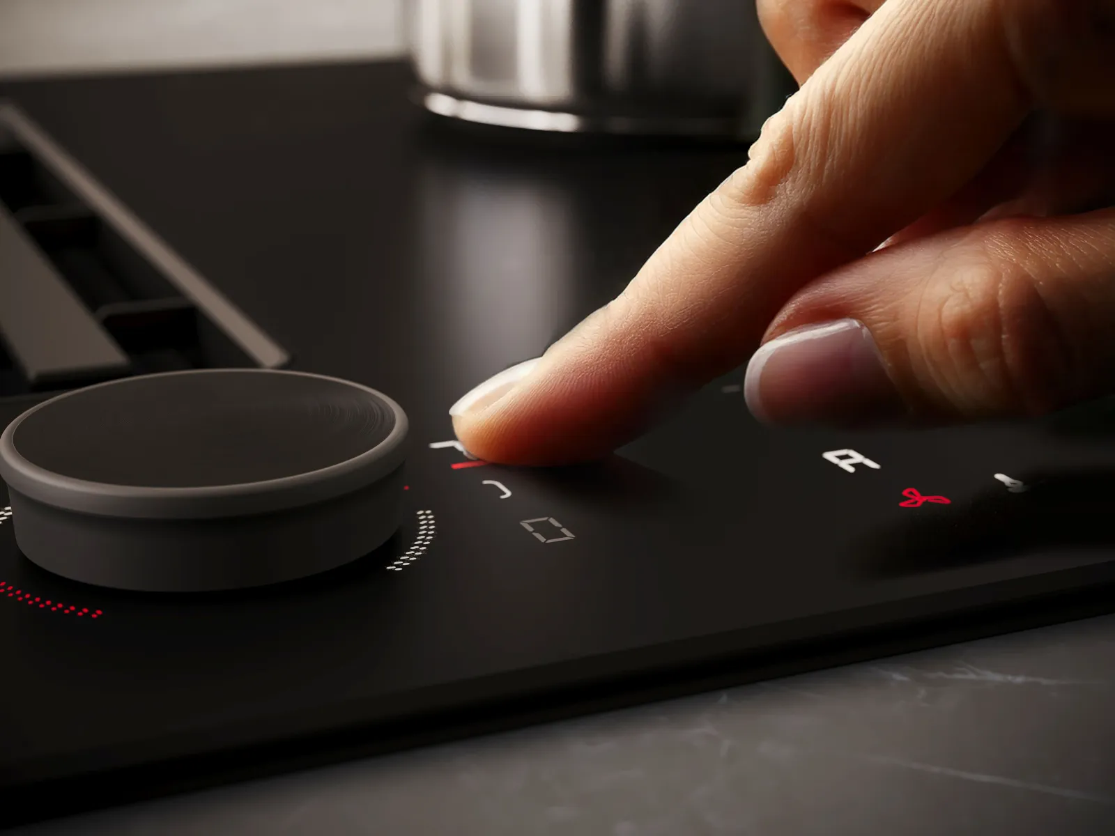 Finger bedient die Touchfläche eines NEFF Matt Black Induktionskochfelds direkt neben dem Twist Pad Flex® Drehregler.
