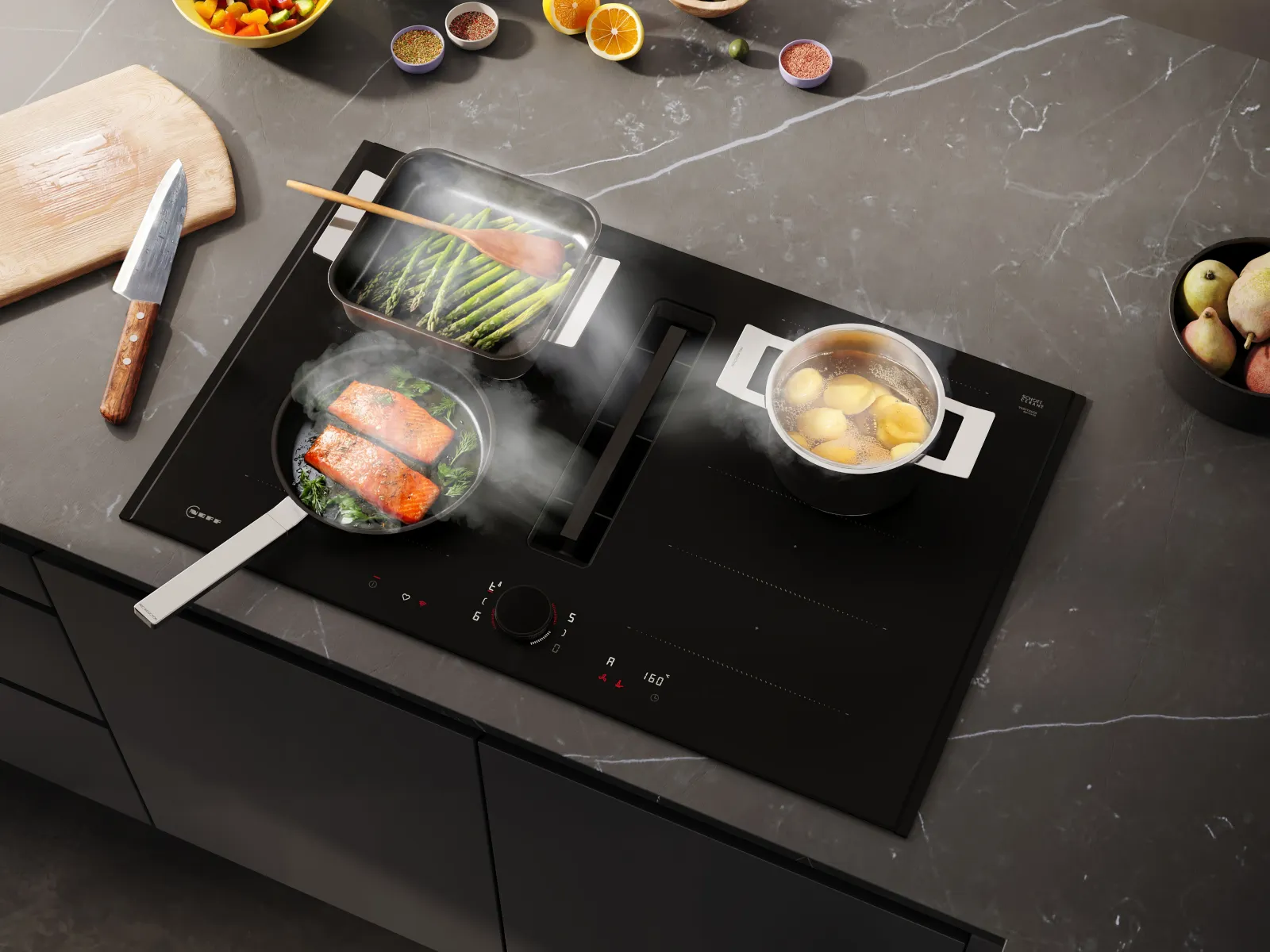 Draufsicht auf das NEFF Matt Black Induktionskochfeld mit mehreren Töpfen beim Kochen, integrierter Kochfeldabzug in Funktion