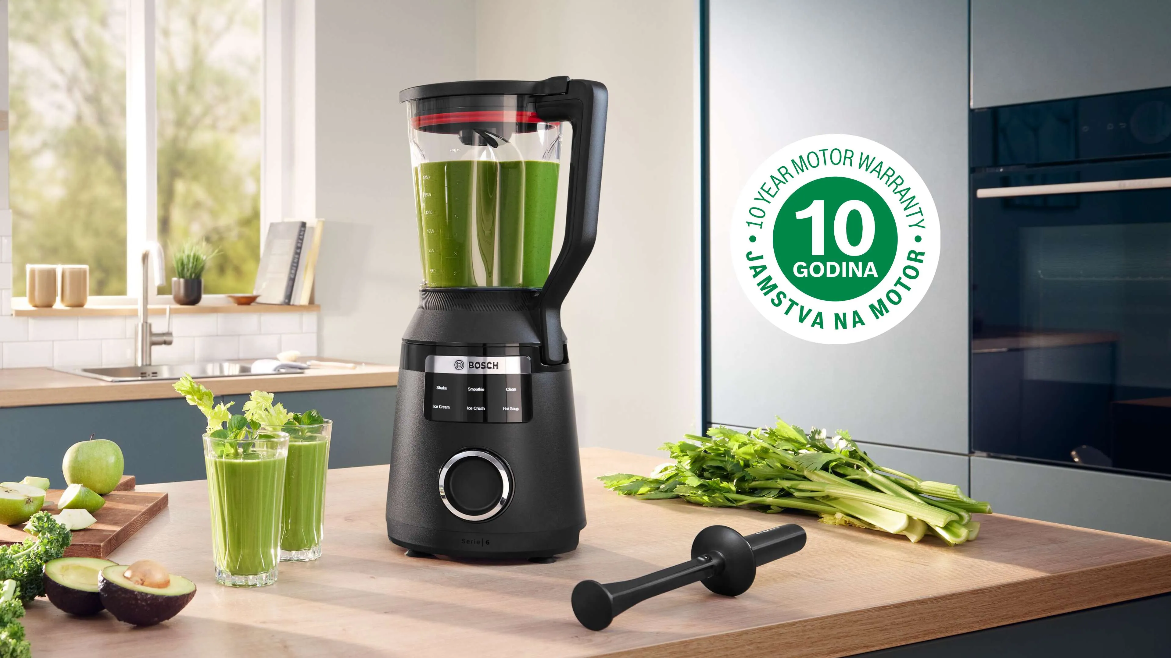 Crni Bosch blender u modernoj kuhinji, pun zelenog smoothija, uz svježu celeriju i čašu smoothija. Prikazana oznaka s 10-godišnjom garancijom na motor.