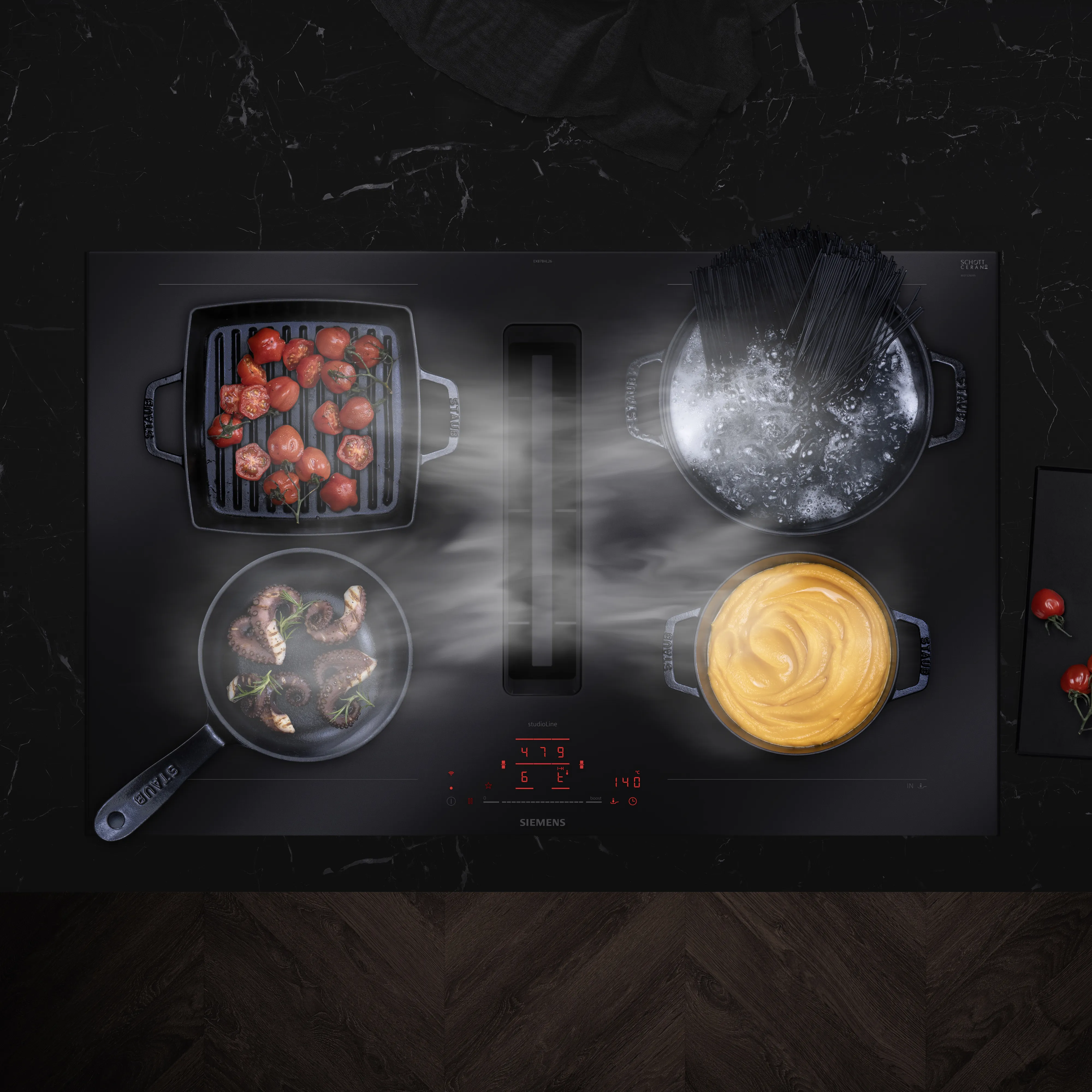 Siemens-Herd mit mehreren Gerichten, die kochen: Tomaten, Pasta, Fleisch und Sauce auf einer schwarzen Oberfläche.