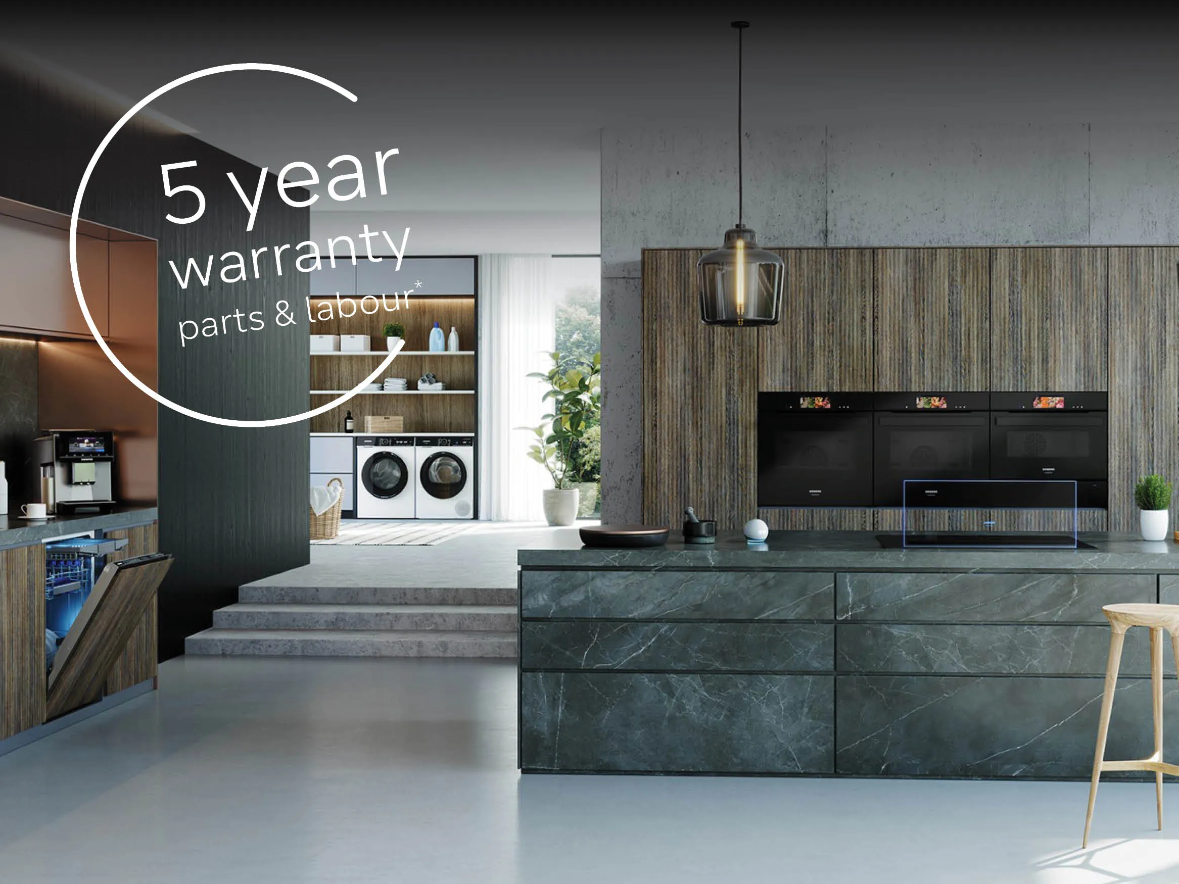 Modern kitchen with marble island, built-in ovens, and a view of a laundry area. Text overlay reads "5 year warranty parts & labour.