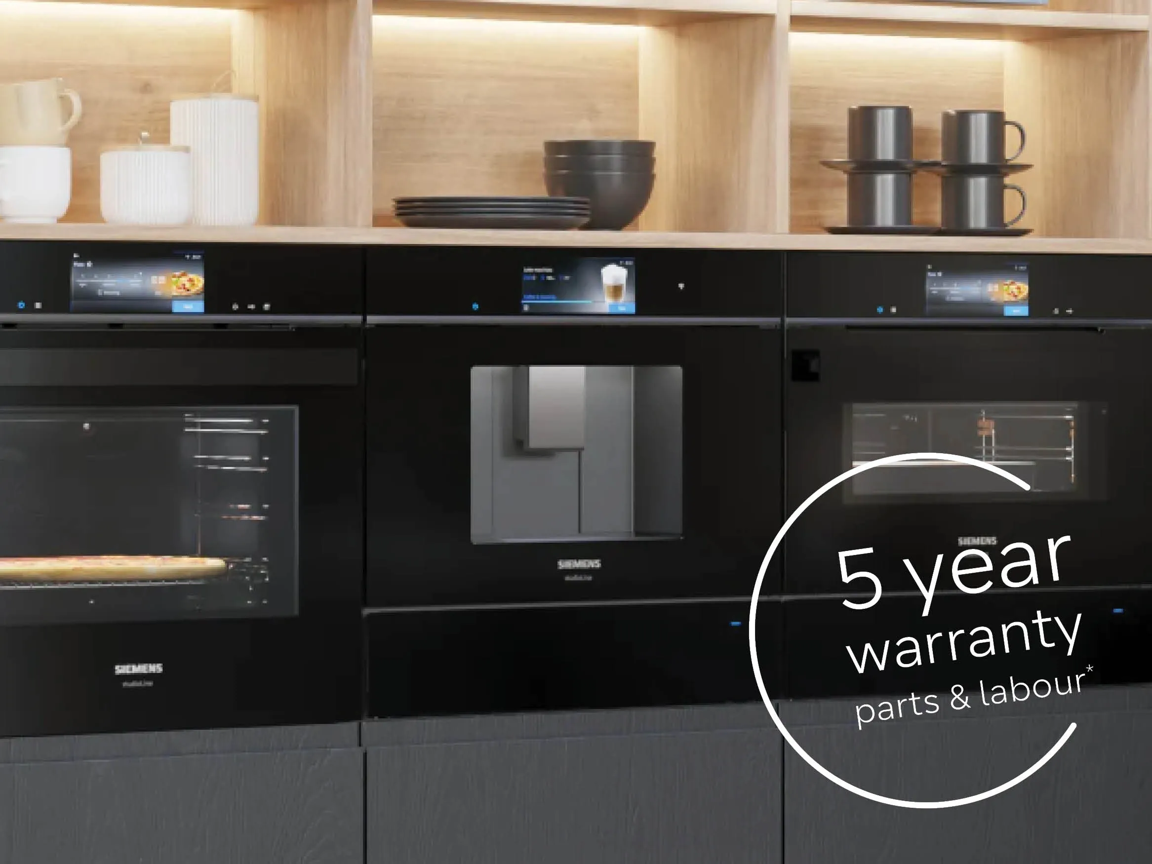 Three sleek Siemens black built-in appliances, with a "5 year warranty, parts & labour" label, set against a wooden shelf backdrop.