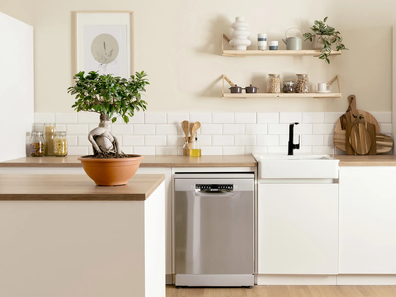 A view across a dining room table into a bright, modern kitchen full of Bosch appliances.